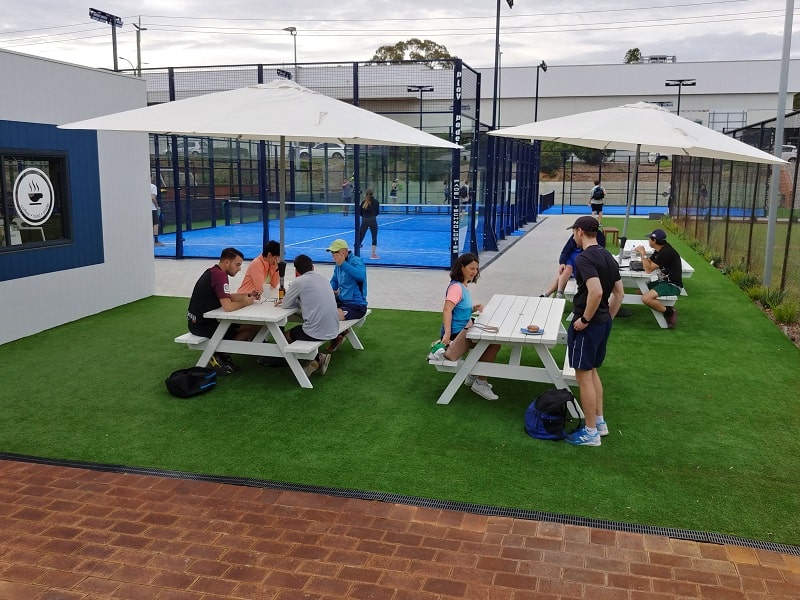 People sitting on picnic tables at a Tennis Club in Brisbane Queensland