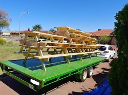 Lots of picnic tables being delivered on a trailer