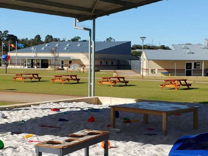 children-prime-picnic-tables-at-a-school-on-grass-min.jpg